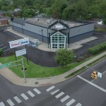 Aerial drone view of a Prime Smile dental building and parking lot located near a street intersection on Arlington Avenue